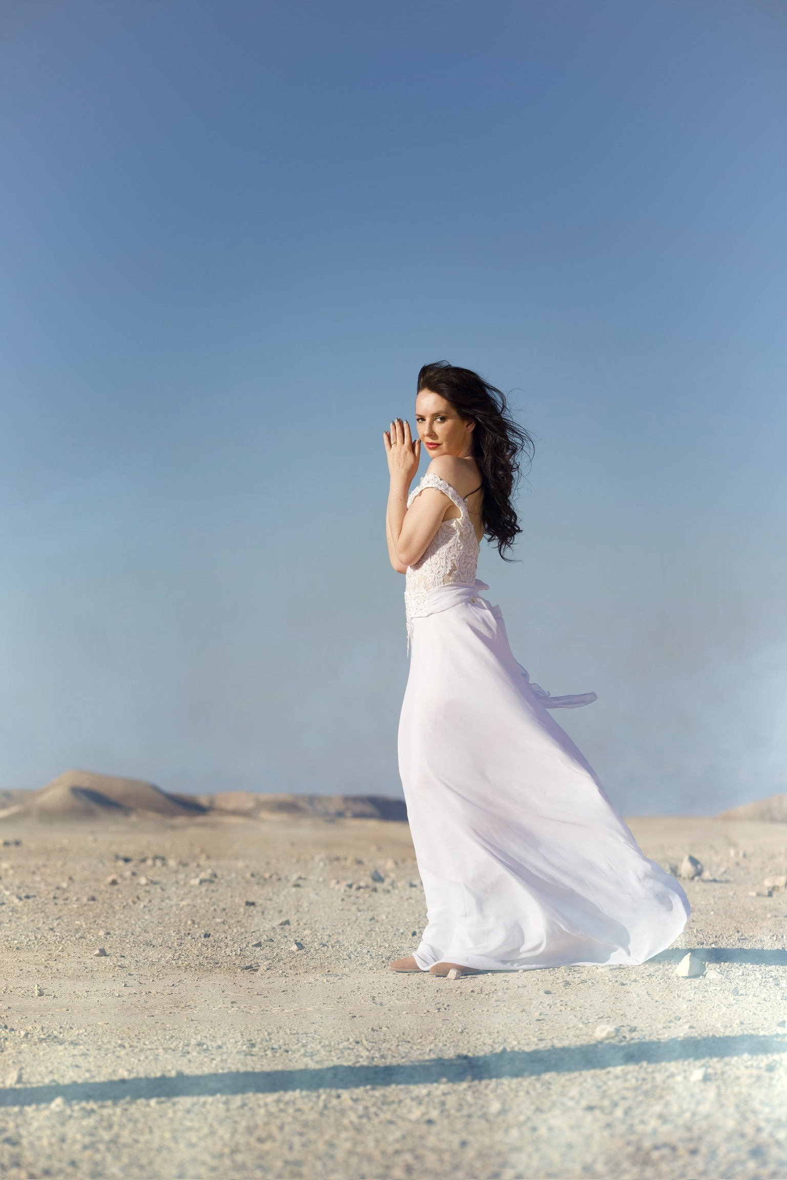 Bride in the desert against blue sky